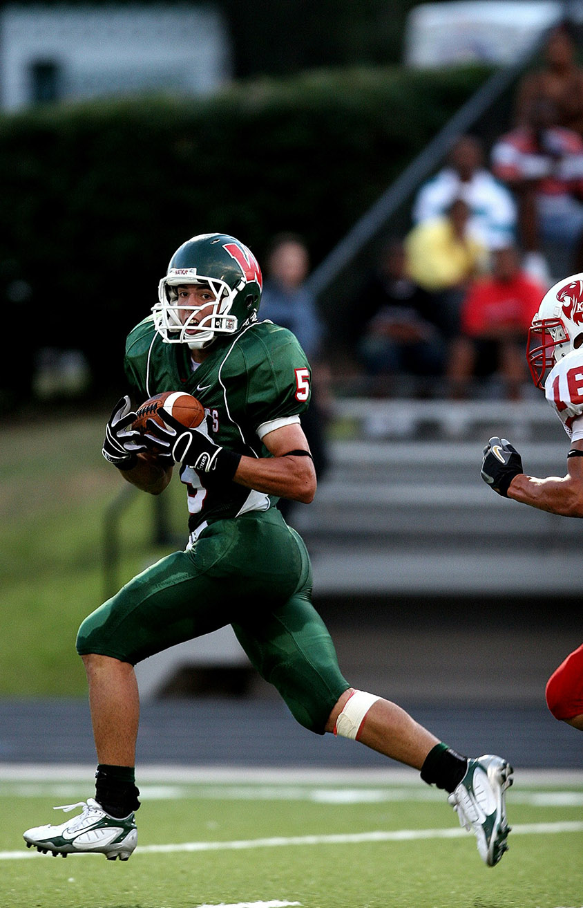man-in-green-5-american-football-jersey-holding-ball